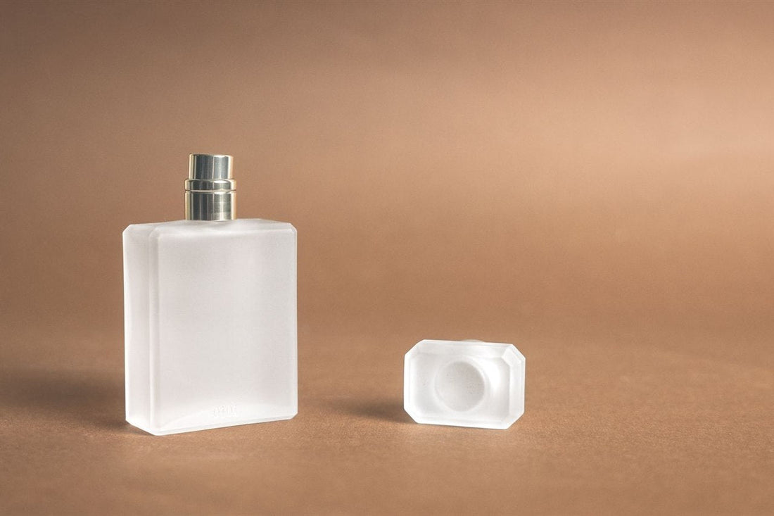 Frasco de perfume sobre fondo cálido